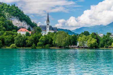 Bir Pletna gemisinden Slovenya 'da yaz mevsiminde kıyıdaki kiliseye doğru giden bir manzara