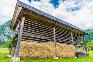 Slovenya 'da Bohinj Gölü yakınlarındaki bir dağlık köyde yaz mevsiminde büyük bir saman kurutma çerçevesinin yakın görüntüsü