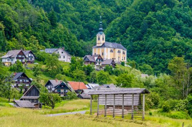 Slovenya 'da Bohinj Gölü' nün yukarısındaki Kranjska alp köyündeki Saint Martin Kilisesi 'ne doğru bir manzara