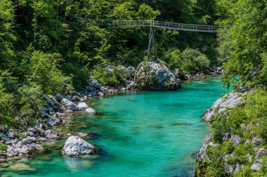 Slovenya 'daki Soca nehrinin kıyısındaki yaya köprüsüne bakan bir manzara