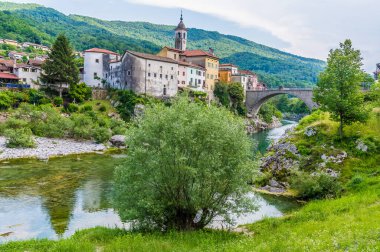 Soca nehrinin kıyısından Slovenya 'daki Kanal ve köprüye doğru bir manzara