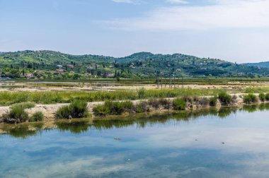 Yaz mevsiminde Slovenya 'nın Piran kenti yakınlarındaki Secovlje' deki tuz tavalarındaki kristalizasyon havuzlarındaki yansımaların manzarası