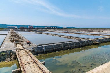 Demiryolu hattı boyunca, yaz aylarında Slovenya 'nın Piran kenti yakınlarındaki Secovlje' deki tuz tavalarında kristalizasyon havuzlarının yanındaki manzara