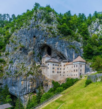 Slovenya 'nın Predjama kentinde yaz aylarında uçurumun kenarına inşa edilen ortaçağ şatosunun manzarası