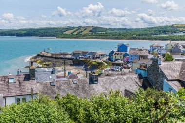 Yaz mevsiminde Batı Galler 'in New Quay kasabasındaki liman ve duvara doğru bir manzara