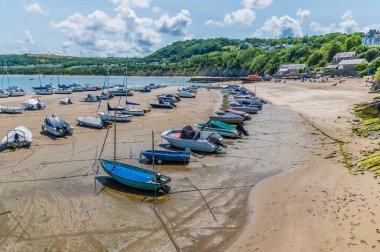 Yazın Galler 'in New Quay kasabasında, alçak gelgitte liman boyunca bir manzara.