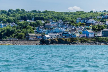 New Quay Körfezi 'nden yazın Galler' in New Quay şehrinin varoşlarına doğru bir manzara.