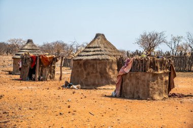 Kurak mevsimde Namibya 'daki geleneksel Himba kabilesi konutlarına doğru bir manzara