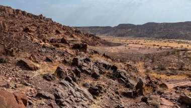 Kurak mevsimde Namibya 'daki Twyfelfontein' de nehir vadisine yayılmış bir kaya manzarası