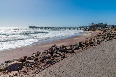 Kurak mevsimde Namibya, Swakopmund 'daki rıhtıma doğru bir sahil manzarası.