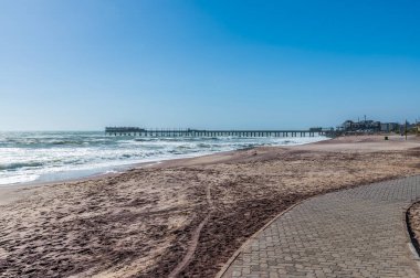 Kıyı şeridi boyunca Swakopmund, Namibya 'daki iskeleye doğru kurak mevsim boyunca bir manzara.