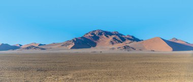 Kurak mevsimde Sossusvlei, Namibya 'da sabahın erken saatlerinde kum tepeleri ve kayalık manzaralar.