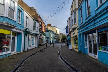 Güneşli bir günde, Tenby, Galler 'deki kasaba duvarlarından uzakta Saint Georges Caddesi' nin aşağısında bir manzara.