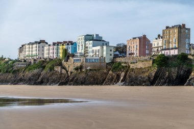 Güneşli bir günde, Tenby, Galler 'de Castle sahilinden renkli binalara doğru bir manzara.