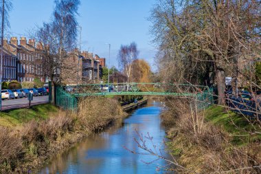 Güneşli bir günde, Spalding 'in merkezindeki bir boru köprüsüne doğru Welland nehri boyunca bir manzara.