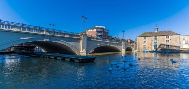 Güneşli bir günde İngiltere 'nin başkenti Peterborough' daki yol köprüsünün yanındaki Nene Nehri 'nden bir manzara