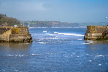 A view out to sea through the harbour entrance in Saundersfoot, Wales on a bright spring day clipart