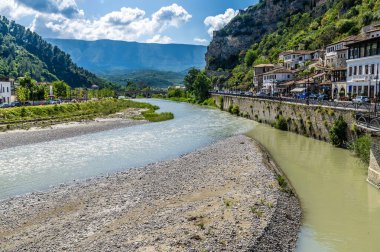 Arnavutluk 'un Berat kentindeki eski taş köprüye doğru Osum nehrinin yukarısından bir manzara