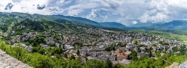 A panorama view from the castle over the city of Gjirokaster and surrounding countryside in Albania in summertime clipart