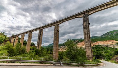 Arnavutluk 'un Podgradec kenti yakınlarındaki artık kullanılmayan komünist döneme ait demiryolunun bir kısmında bir köprüye doğru bir manzara