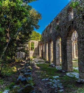 Arnavutluk 'un Butrint kentindeki antik harabelerde Büyük Bazilika' nın yanına yaklaşan bir manzara