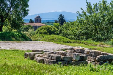 Arnavutluk 'un Apollonia kentinde yaz aylarında Roma harabelerinde bulunan kubbeli bir binaya yönelik kalıntıların geçtiği bir manzara