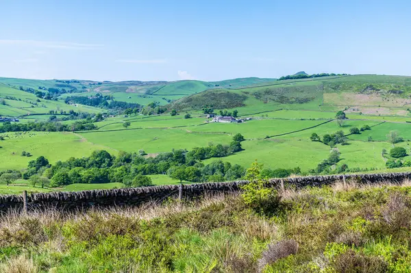 stock image A view over a drystone wall towards typical dales scenery from the path leading to Luds Church in Staffordshire in summertime