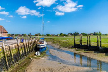 Bosham Nehri 'nin üzerinden Bosham, Batı Sussex' in rıhtımından yaz mevsiminde alçak gelgitte bir manzara