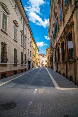 İtalya 'nın Faenza şehrinde yazın renkli binaların olduğu sessiz bir caddenin manzarası.