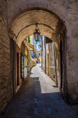 Yaz mevsiminde İtalya 'nın San Marino kentindeki dar bir sokakta kemer boyunca uzanan manzara.