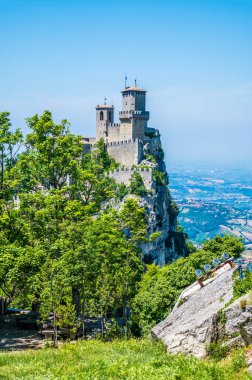 Yaz mevsiminde İtalya 'nın San Marino kentindeki ilk kuleye doğru ağaçların arasından bir manzara
