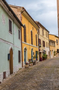 A view of the top end of the main street in the hilltop fortress village of Sant Andrea di Suasa, Italy in summertime clipart