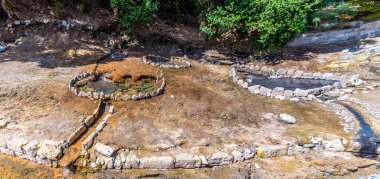 A view looking down on fumarole craters in the town of Furnas on the island of San Miguel in the Azores in summertime clipart