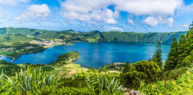 Yazın Azores 'de San Miguel adasında bulunan Yedi Şehir bölgesindeki Mavi Göl boyunca uzanan bir manzara.