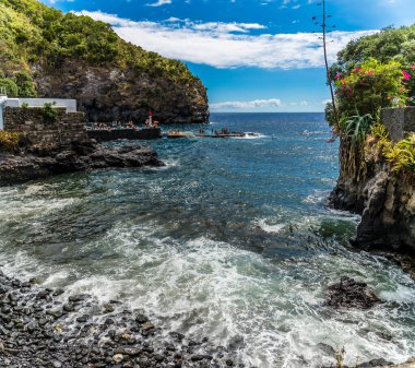 Yazın Azores 'de San Miguel adasındaki Caloura' daki volkanik siyah kum plajına doğru bir manzara.