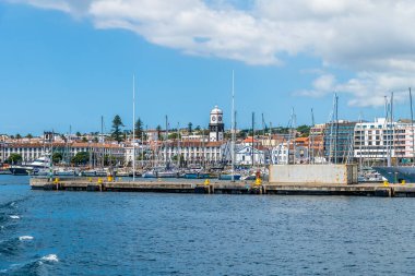 Yaz mevsiminde San Miguel adasındaki Ponta Delgada liman duvarını aşan bir teknenin manzarası.