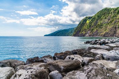 Yazın Azores 'de Sao Miguel adasındaki Povoacao kasabasında kayalık sahili geçince körfeze doğru bir manzara.