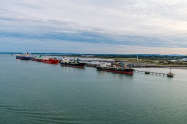 Southampton suyundan bir manzara sonbaharda gün batımında Fawley 'deki Petrol Rafinerisi' ne demirlemiş tanker hattı boyunca.