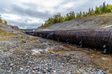 Newfoundland, Kanada 'da, sonbaharda Brook Köşesi' nin yukarısındaki sızdıran ahşap bir su borusunun doğusuna doğru bir manzara.