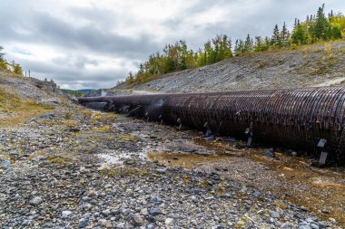 A view eastward beside a leaky wooden-stave water pipe above Corner Brook in Newfoundland, Canada in the fall clipart