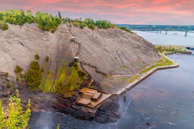 A view down towards the viewing platforms from the top of the Montmorency falls near Quebec City, Canada at sunset in the fall clipart