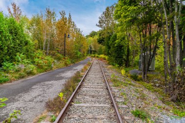 A view at the bottom of the Montmorency falls up a railway line beside the Saint Lawrence river near Quebec City, Canada in the fall clipart