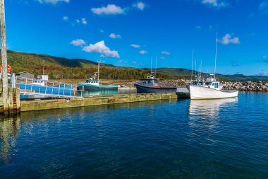 Sonbaharda Kanada, Nova Scotia 'daki Cabot Patikası' ndaki Little River Limanı 'ndaki iskelenin yanında demirlemiş bir tekne manzarası.