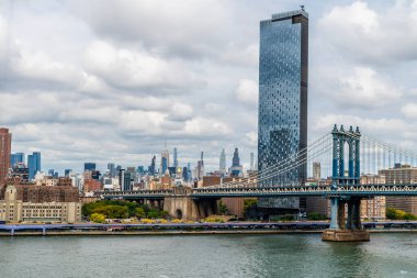 A view from the Brooklyn Bridge towards the Manhattan bridge and mid New York, in the fall clipart