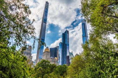 Sonbaharda Manhattan, New York 'taki Central Park' ın etrafındaki gökdelenlere doğru ağaçların arasından bir görüntü.