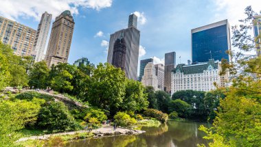 Havuzun karşısındaki Gapstow Köprüsü 'nden New York, Manhattan' daki Central Park çevresindeki gökdelenlere doğru bir manzara.