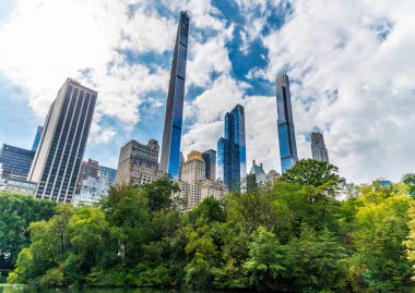 Sonbaharda Manhattan, New York 'taki Central Park çevresindeki gökdelenlere doğru göletin yanında bir manzara.