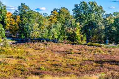 A view towards the North Bridge over the Sudbury River at Concord, Massachusetts near Boston in the fall clipart