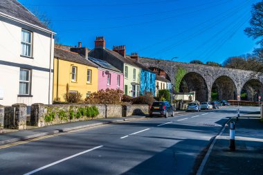 Sokağın aşağısındaki Tenby, Pembrokeshire 'de güneşli bir bahar gününde demiryolu viyadüküne giden bir manzara.