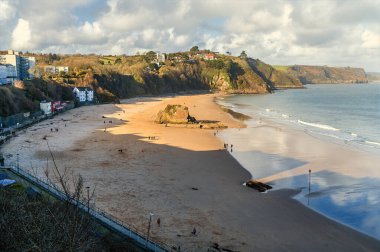 Güneşli bir bahar gününde, Tenby, Pembrokeshire sahilindeki North Beach boyunca bir manzara.